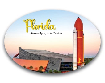 May include: A yellow oval sticker with the text "Florida Kennedy Space Center" and an image of a red and white rocket against a blue sky.