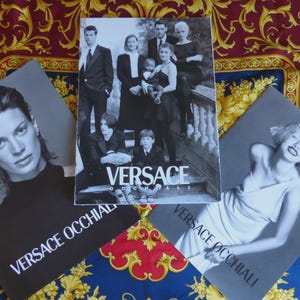 Puede incluir: Tres anuncios de moda Versace se muestran sobre una tela estampada. El anuncio central presenta un grupo de personas. Otros dos anuncios muestran modelos individuales. El texto "VERSACE OCCHIALI" es visible en dos de los anuncios.