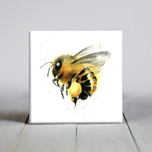 May include: Watercolor painting of a bee in flight. The bee is yellow and black with a brown head and a white background.