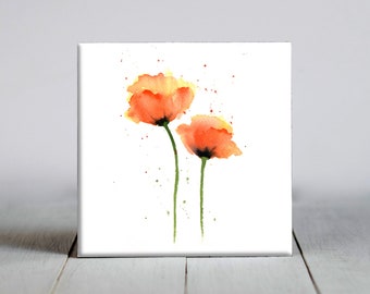 May include: Watercolor painting of two orange poppies with green stems against a white background. The flowers have yellow highlights and a few green and red paint splatters. The artwork is on a square white canvas.