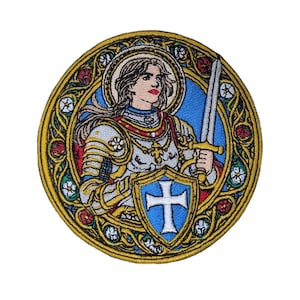 May include: A circular embroidered patch featuring a figure in silver armor holding a sword and a blue shield with a white cross. The design is framed by a gold border with intricate floral patterns in red, white, and blue, resembling stained glass.