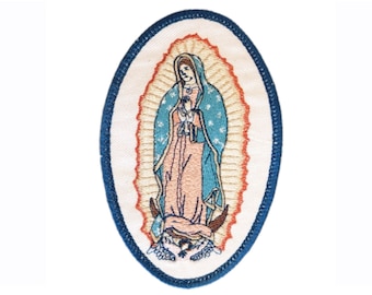 May include: Embroidered oval patch featuring the Virgin of Guadalupe. The image depicts a figure in a blue cloak and pink robe, surrounded by a halo of light. The patch has a white background with a blue border.