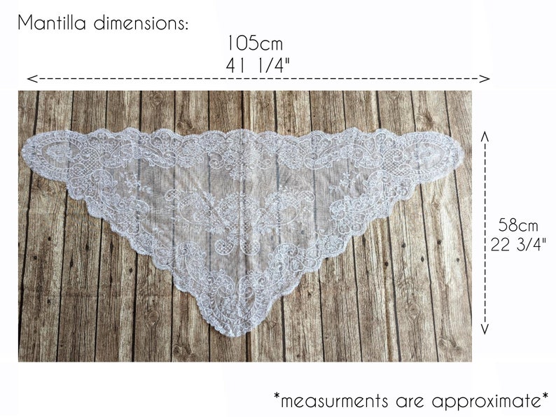 May include: White lace mantilla with a scalloped edge. The mantilla measures 41 1/4 inches by 22 3/4 inches. *Measurements are approximate*