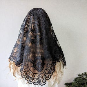 Puede incluir: Mantilla de encaje negro con un patr&oacute;n floral. El encaje es delicado e intrincado, y la mantilla es un hermoso accesorio para cualquier ocasi&oacute;n especial.
