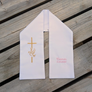 May include: White religious stole with gold cross and dove embroidery. The stole has the name "Carmen" and the date "5.05.2025" embroidered in pink. The stole is made of a soft fabric.