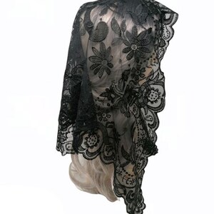 May include: Black lace mantilla with floral embroidery. The lace is delicate and intricate, and the embroidery is detailed and elegant.