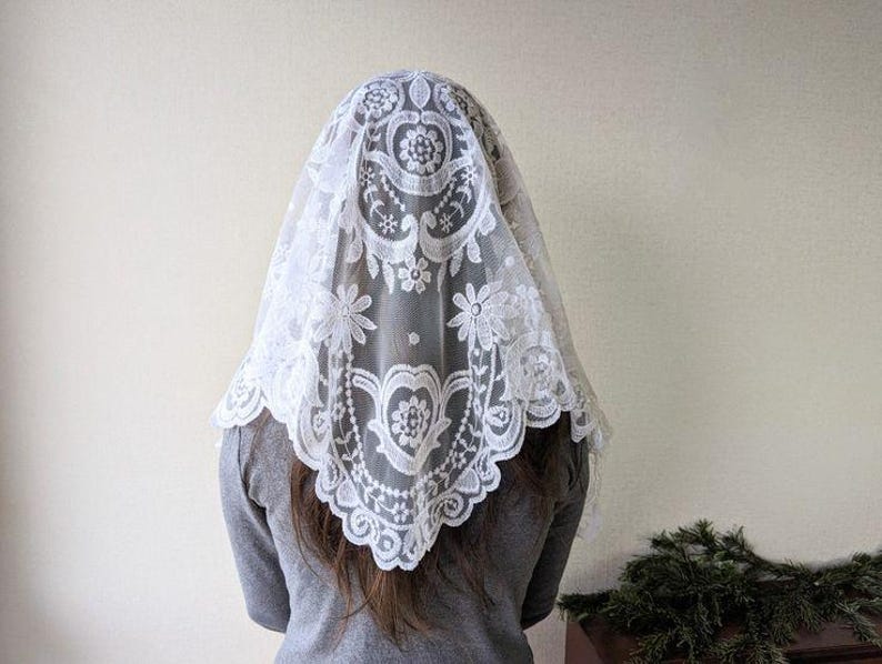 Puede incluir: Mantilla de encaje blanco con un patr&oacute;n floral. El encaje es delicado y tiene un borde festoneado.