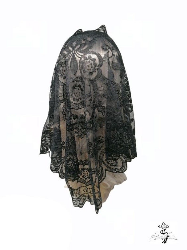 May include: Black lace veil with a floral pattern. The veil is made of delicate, sheer fabric and has a scalloped edge.