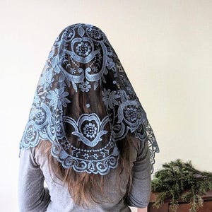 May include: A blue lace mantilla with floral embroidery. The lace is delicate and intricate, and the veil is perfect for a special occasion.