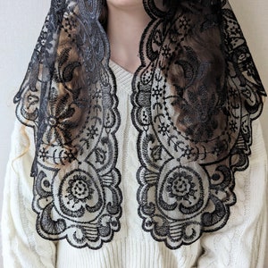 May include: Black lace mantilla with a floral design. The lace is delicate and intricate, and the mantilla is a beautiful accessory for any occasion.