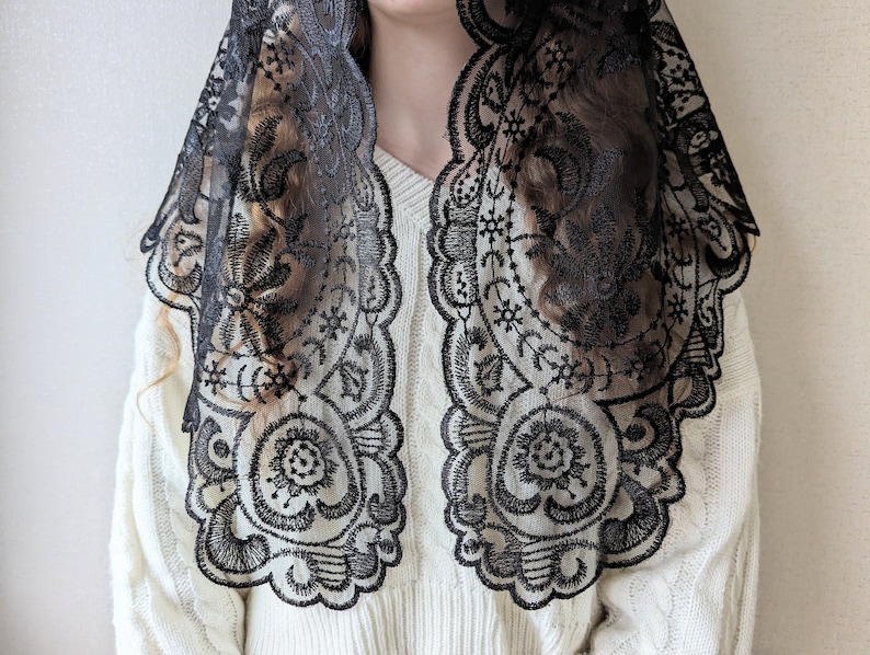 May include: Black lace mantilla with a floral design. The lace is delicate and intricate, and the mantilla is a beautiful accessory for any occasion.