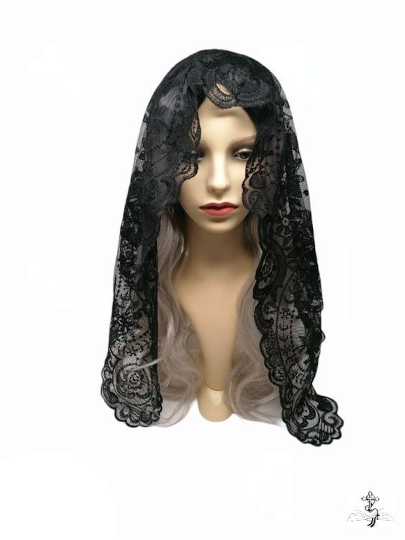 May include: Black lace mantilla with a floral pattern. The mantilla is draped over a mannequin's head.