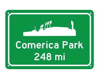 May include: Green road sign with white text and a silhouette of a baseball stadium. The sign reads "Comerica Park 248 mi".