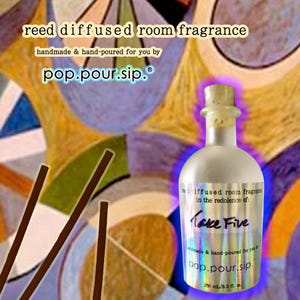 May include: A reed diffused room fragrance bottle with a cork stopper. The label reads "Take Five" and "pop.pour.sip." The bottle contains 250 ml / 8.5 fl oz of fragrance. Brown reeds are in the foreground.