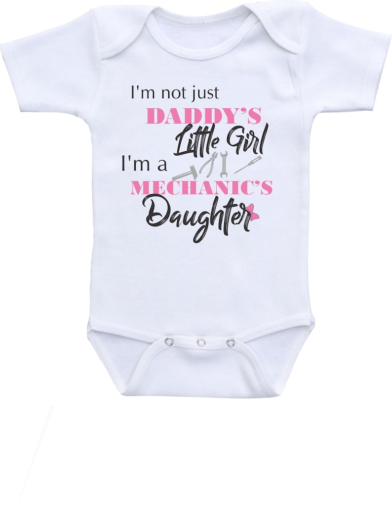 May include: White baby onesie with short sleeves and pink text that reads "I'm not just Daddy's Little Girl I'm a Mechanic's Daughter".