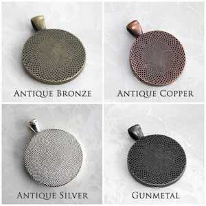 May include: Four round metal pendants in different finishes: antique bronze, antique copper, antique silver, and gunmetal. Each pendant has a circular design with a textured surface.