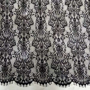 Puede incluir: Tela de encaje negra con un delicado patrón floral. El encaje tiene un borde festoneado.