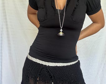 Top vintage negro de estilo Y2K con cuello de volantes y abertura en la espalda.