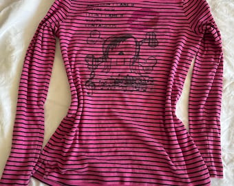 Camiseta de manga larga reciclada con estampado de calavera y tibias cruzadas emo de Pierce The Veil en rosa y negro, notas musicales ensangrentadas y labios manchados de sangre.
