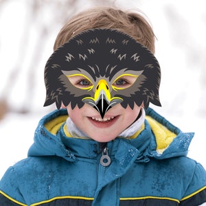 May include: A paper eagle mask featuring dark grey and black feathers, a bright yellow beak, and sharp black details around the eyes. The mask includes cutouts for the eyes and is printed with the text www.LMEPRINTABLES.Etsy.com at the top.