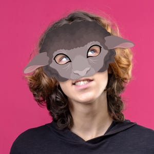 May include: A gray sheep mask with large ears and a detailed face is worn by a person. The mask covers the upper face, with the person's eyes visible, looking upwards. The background is a solid magenta color. The website address www.LMEPRINTABLES.Etsy.com is visible at the bottom.