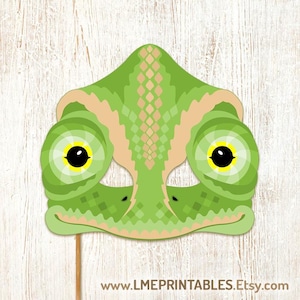 Op de afbeelding: Groen en bruin kameleonmasker met grote gele ogen en een stokje aan de onderkant. Het masker is geprint op stevig papier en is klaar om uit te knippen en te gebruiken voor een feestje of toneelstuk.