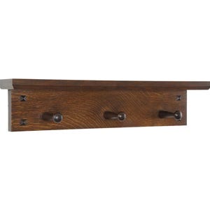 May include: A wooden shelf with three hooks, perfect for hanging coats, hats, or bags. The shelf is made of dark wood and has a simple, rustic design.