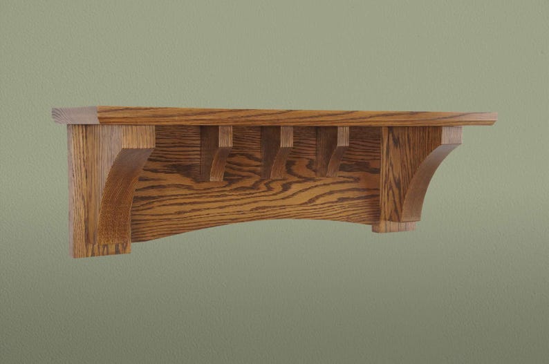 Op de afbeelding: Een houten plank met een gebogen voorrand en decoratieve uitsparingen. De plank is gemaakt van lichtbruin hout met een natuurlijke houtnerf.