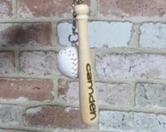 May include: Wooden baseball bat keychain with a miniature baseball attached and the word "camden" engraved on the bat.