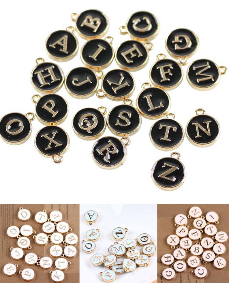 May include: Assortment of gold-colored alphabet letter charms with black enamel. Each charm features a single letter in a gold font. The charms are round and have a small loop at the top for attaching to jewelry or other crafts.