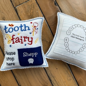 Tooth fairy pillow with embroidered details.  It has a pocket for tooth exchange.  Personalized with the child's name embroidered on the pocket.  In the back it has a tooth chart to keep track of the dates of the lost teeth.