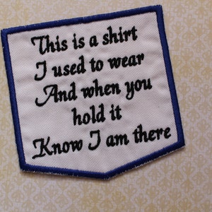 May include: White embroidered patch with a blue border. The patch features the text "This is a shirt I used to wear And when you hold it Know I am there" in black script.