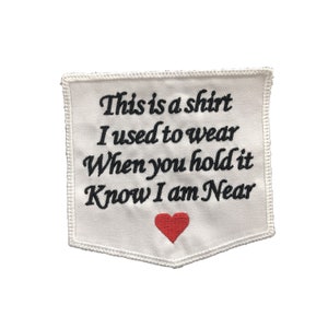 May include: White fabric patch with black embroidered text that reads "This is a shirt I used to wear When you hold it Know I am Near" and a red heart.