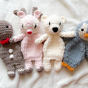 May include: Four handmade crochet stuffed animals: a gingerbread man with a red bow tie, a pink reindeer with brown antlers, a white polar bear, and a blue and white penguin with an orange beak and feet. These plush toys are perfect for children.