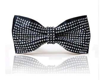 Könnte beinhalten: Eine schwarze Fliege mit einem glitzernden Strass-Design.