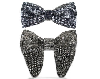 Könnte beinhalten: Zwei metallisch-schwarze Fliegen auf weißem Hintergrund. Die obere Fliege ist ein Standardmodell, die untere eine Butterfly-Fliege. Der Text "BT# 17026 Metallic Black Standard Bow Tie" und "BT# 21021 Metallic Black Butterfly Bow Tie" sind sichtbar.