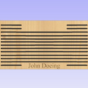 Puede incluir: Un panel de pared de madera con un patr&oacute;n decorativo de ranuras horizontales. El panel es de color marr&oacute;n claro y tiene el nombre "John Doeing" grabado en el centro inferior.
