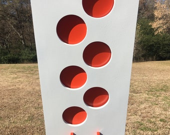 May include: White target with five orange circles cut out. The target is mounted on a white pole.