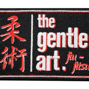 May include: A rectangular embroidered patch with a black background and a red border. The left side features red Japanese kanji characters. The right side displays the white text "the gentle art" and "jiu-jitsu" with a red drop shadow effect.