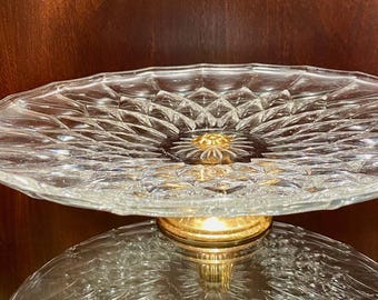 Plato de cristal para pasteles/postres con pedestal dorado.