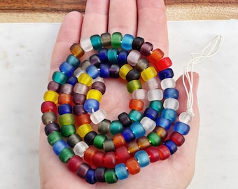 May include: A strand of colorful glass beads in various shades of blue, green, red, yellow, and white. The beads are frosted and have a slightly irregular shape.
