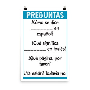 May include: A blue and white poster with the text "PREGUNTAS" in large, bold letters. The poster features a series of questions in Spanish, including "¿Cómo se dice ____ en español?" and "¿Qué significa ____ en inglés?"