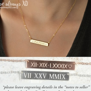 Peut inclure: Un collier dor&eacute; avec une barre grav&eacute;e de chiffres romains. Le collier est port&eacute; par une personne. D'autres colliers en or rose et argent sont pr&eacute;sent&eacute;s en dessous. Le texte comprend "LoveAlwaysXO.com" et des instructions pour la gravure.