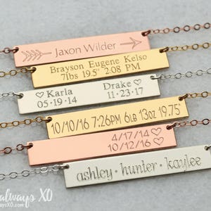 Peut inclure: Plusieurs colliers personnalis&eacute;s avec des barres grav&eacute;es. Chaque pendentif rectangulaire est grav&eacute; de noms, de dates et de mesures, et est reli&eacute; &agrave; de fines cha&icirc;nes. Le texte comprend des noms comme Jaxon Wilder et Karla.