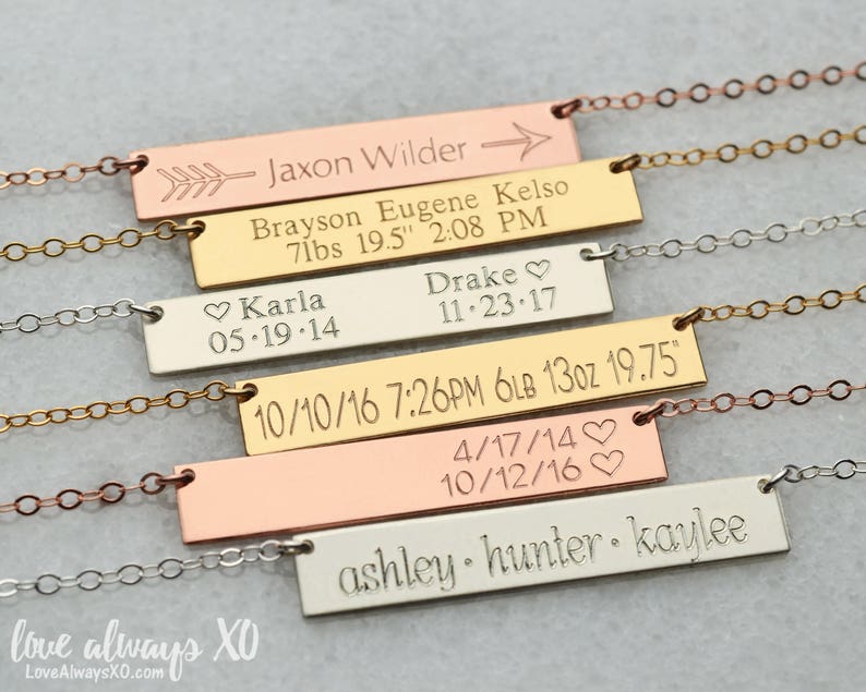 Peut inclure: Plusieurs colliers personnalis&eacute;s avec des barres grav&eacute;es. Chaque pendentif rectangulaire est grav&eacute; de noms, de dates et de mesures, et est reli&eacute; &agrave; de fines cha&icirc;nes. Le texte comprend des noms comme Jaxon Wilder et Karla.