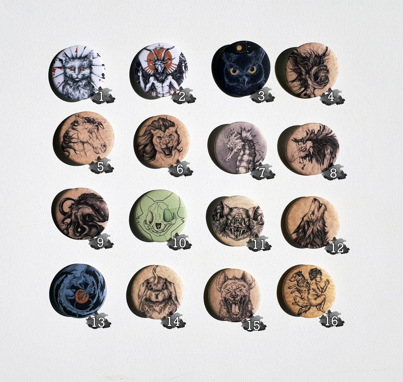 K&ouml;nnte beinhalten: Set mit 16 runden Pins mit verschiedenen Schwarzwei&szlig;-Illustrationen. Die Pins zeigen eine Vielzahl von Kreaturen, darunter eine Katze, einen Wolf, ein Seepferdchen, einen Sch&auml;del und einen Schmetterling. Die Pins haben alle einen Durchmesser von etwa 2,5 cm.