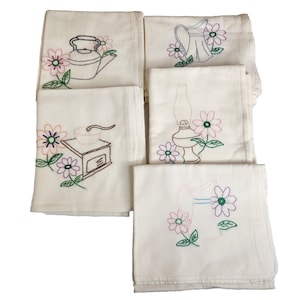 May include: Set of five white tea towels with embroidered floral designs and kitchen tools. The designs include a coffee grinder, a teapot, a lamp, and two pitchers.