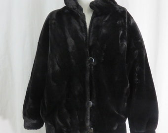 May include: A black faux fur jacket with a button closure and a stand-up collar.