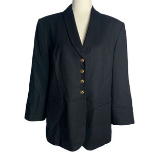 May include: A black blazer with a notched collar and five gold buttons. The blazer has long sleeves and a single pocket on each side.