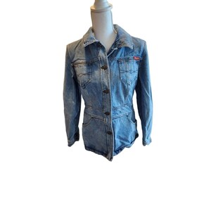 May include: A blue denim jacket with a button closure and a red logo on the right pocket.